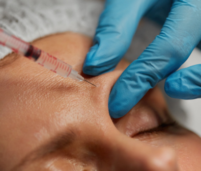 Closeup Cosmetologist Hand With Syringe Injecting Liquid Into Human Skin
