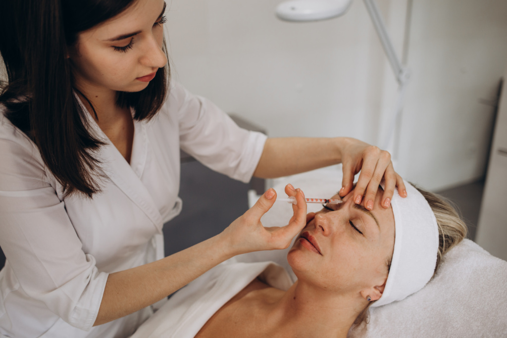 Smile Lifting And Lip Augmentation. Beautician Doctor Hands Doing Beauty Procedure To Female Face With Syringe. Young Woman's Mouth Countouring With Filler Injection. Marionette Lines Treatment.